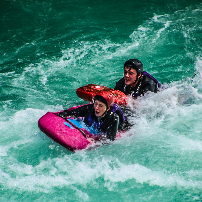 a young girl riding a wave on a surfboard in the water